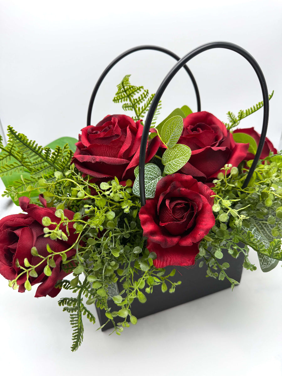 elegant deep red rose and greenery arrangement in black gift bag