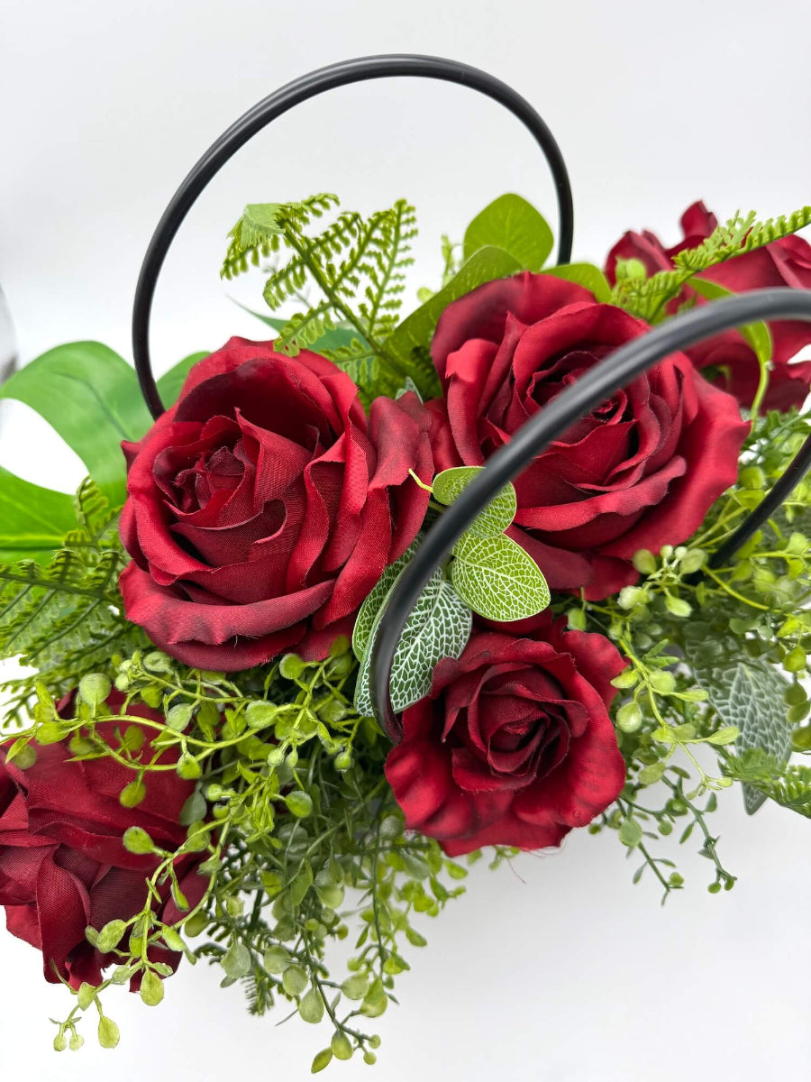 Black gift bag of red roses with greenery realistic and elegant arrangement
