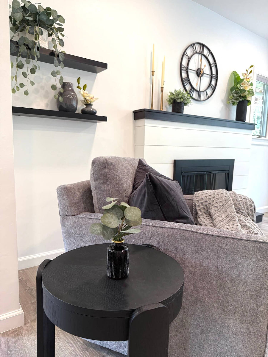 living room with small faux silver dollar eucalyptus arrangement in elegant black ceramic vase