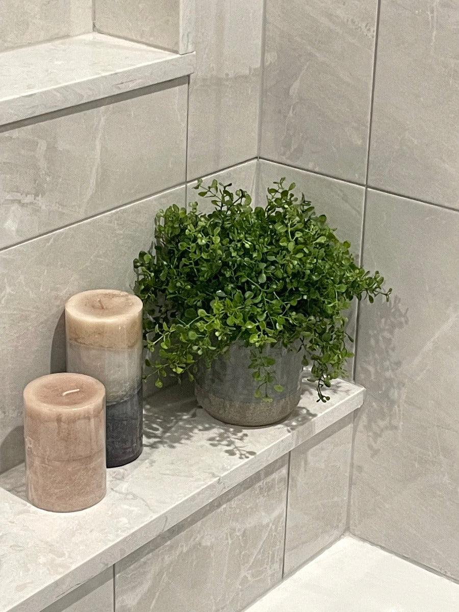 realistic looking vivid green faux plant in gray ceramic pot