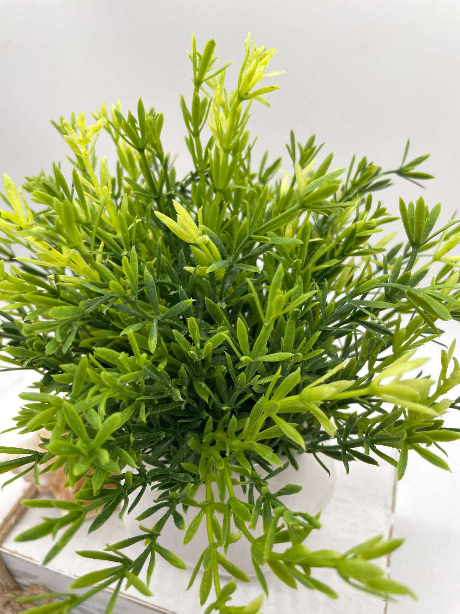vivid green artificial plant in small ceramic pot