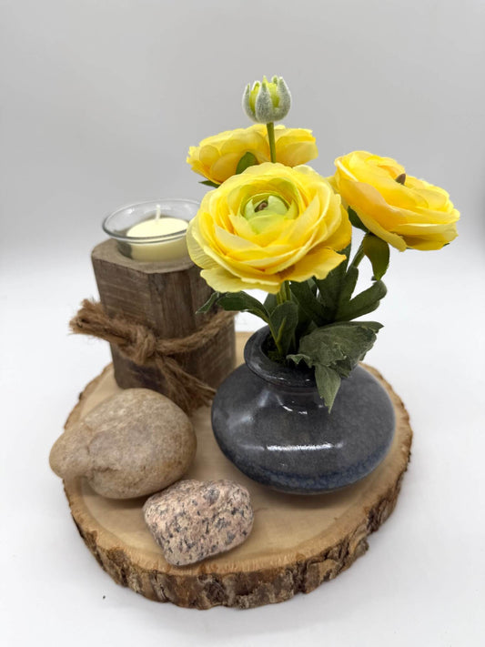 small yellow runcunculas bouquet in gray ceramic vase