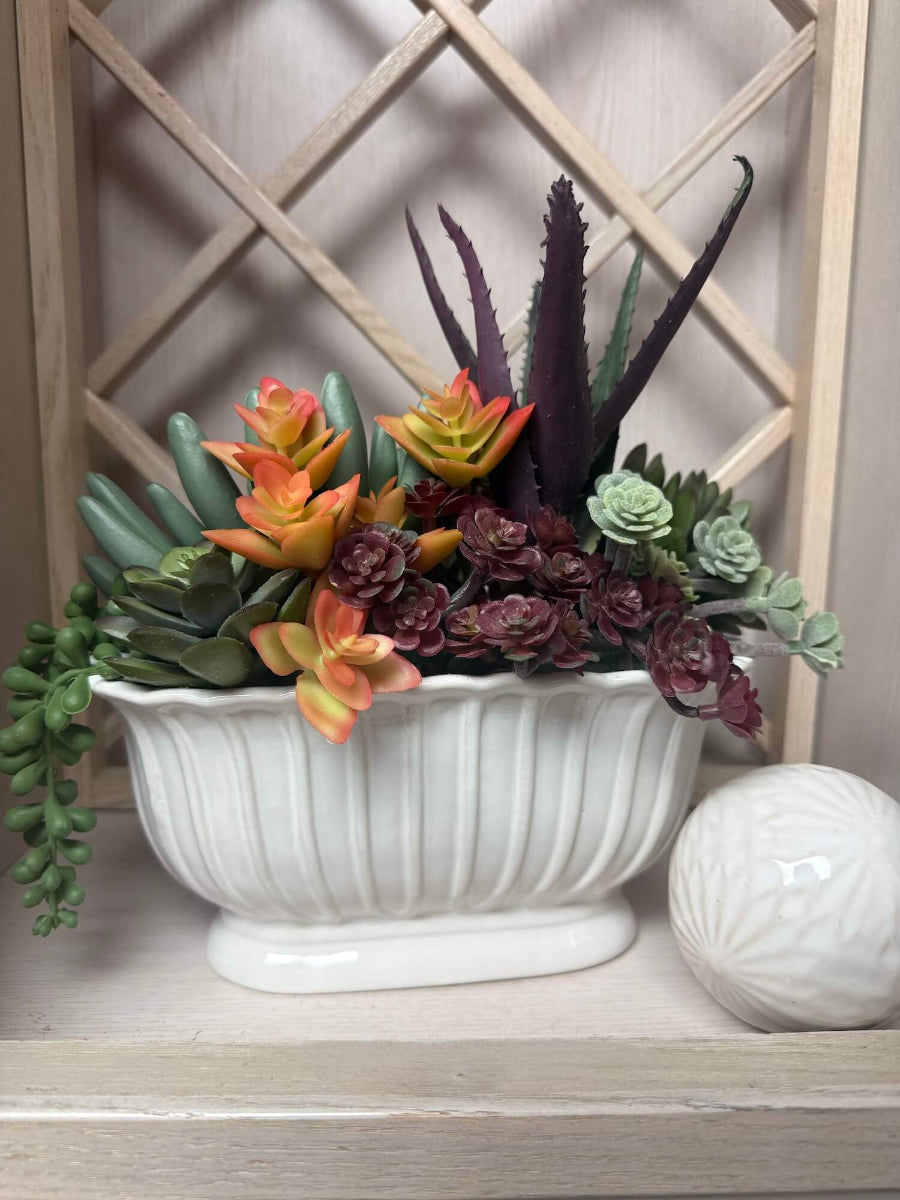 realistic looking faux succulent arrangement in long ceramic textured vase