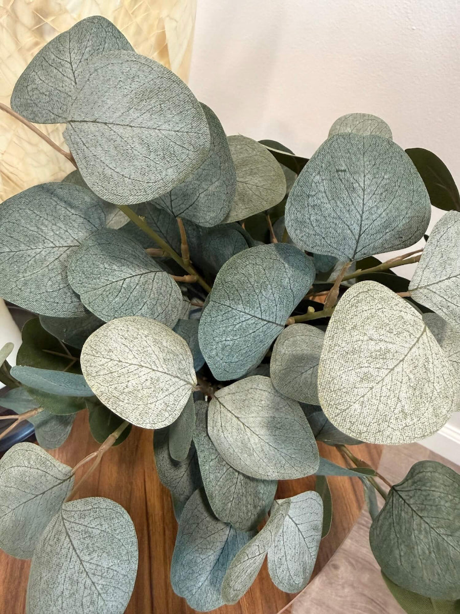 close up for elegant realistic lush silver dollar eucalyptus in stone-like ceramic beige vase