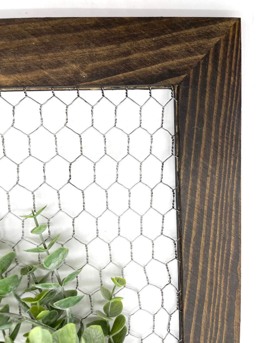 window frame with chicken wire decorated with realistic green eucalyptus wreath