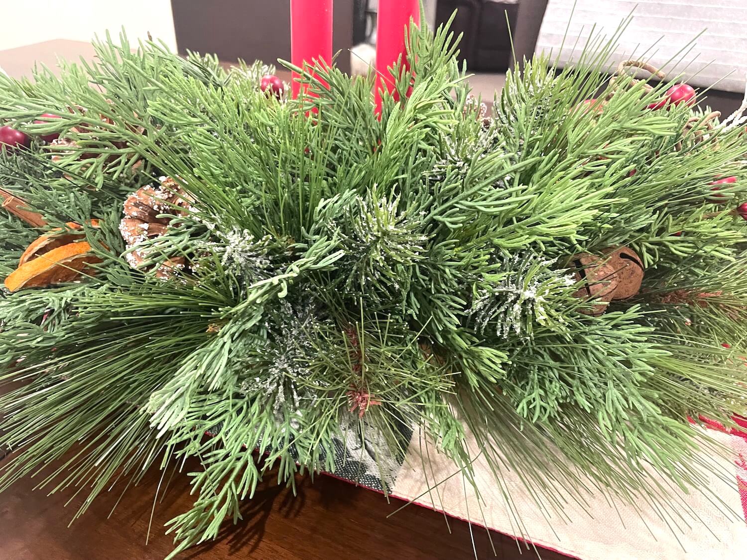 back of lush realistic looking christmas centerpiece with evergreen and greenery stems