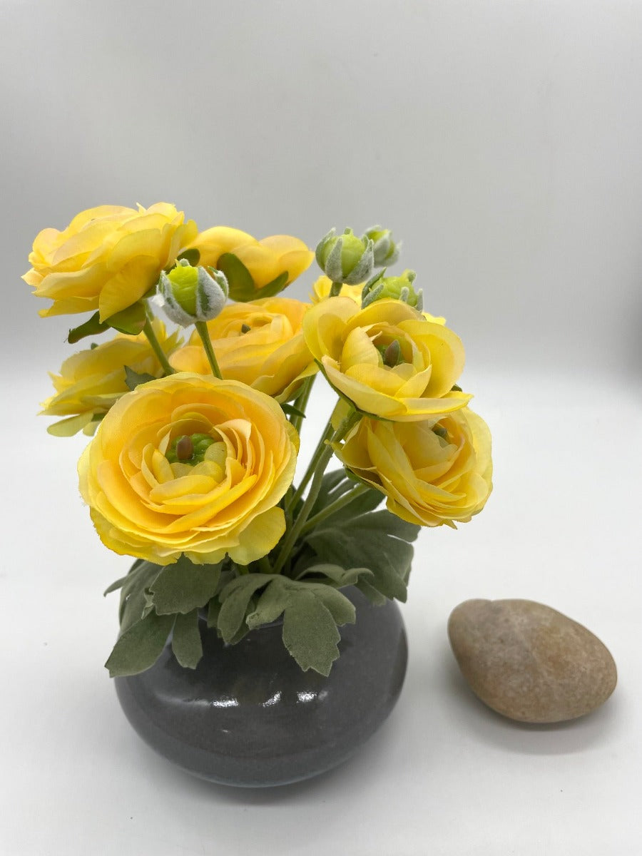 faux yellow ranunculus flowers bouquest in gray ceramic vase