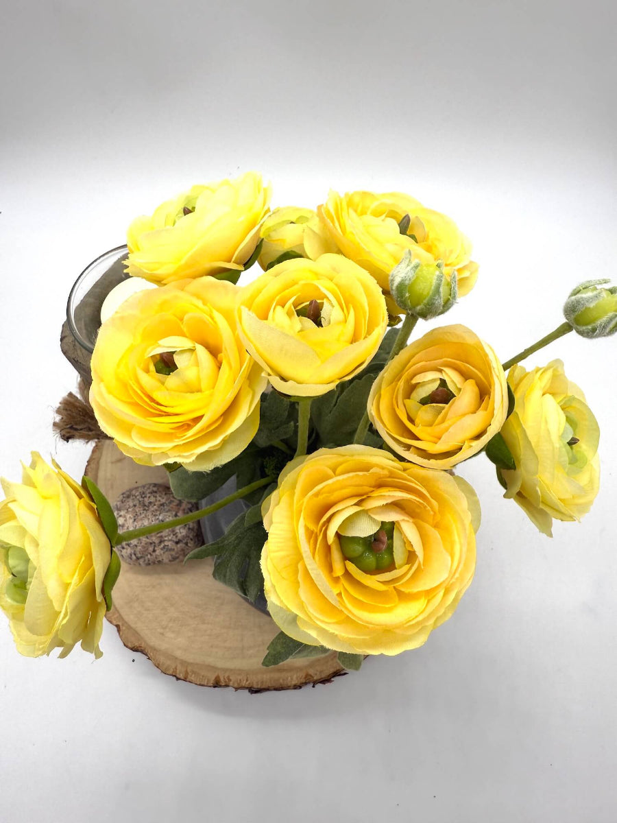 view from top realistic yellow runcunculus flower bouquet in gray ceramic vase