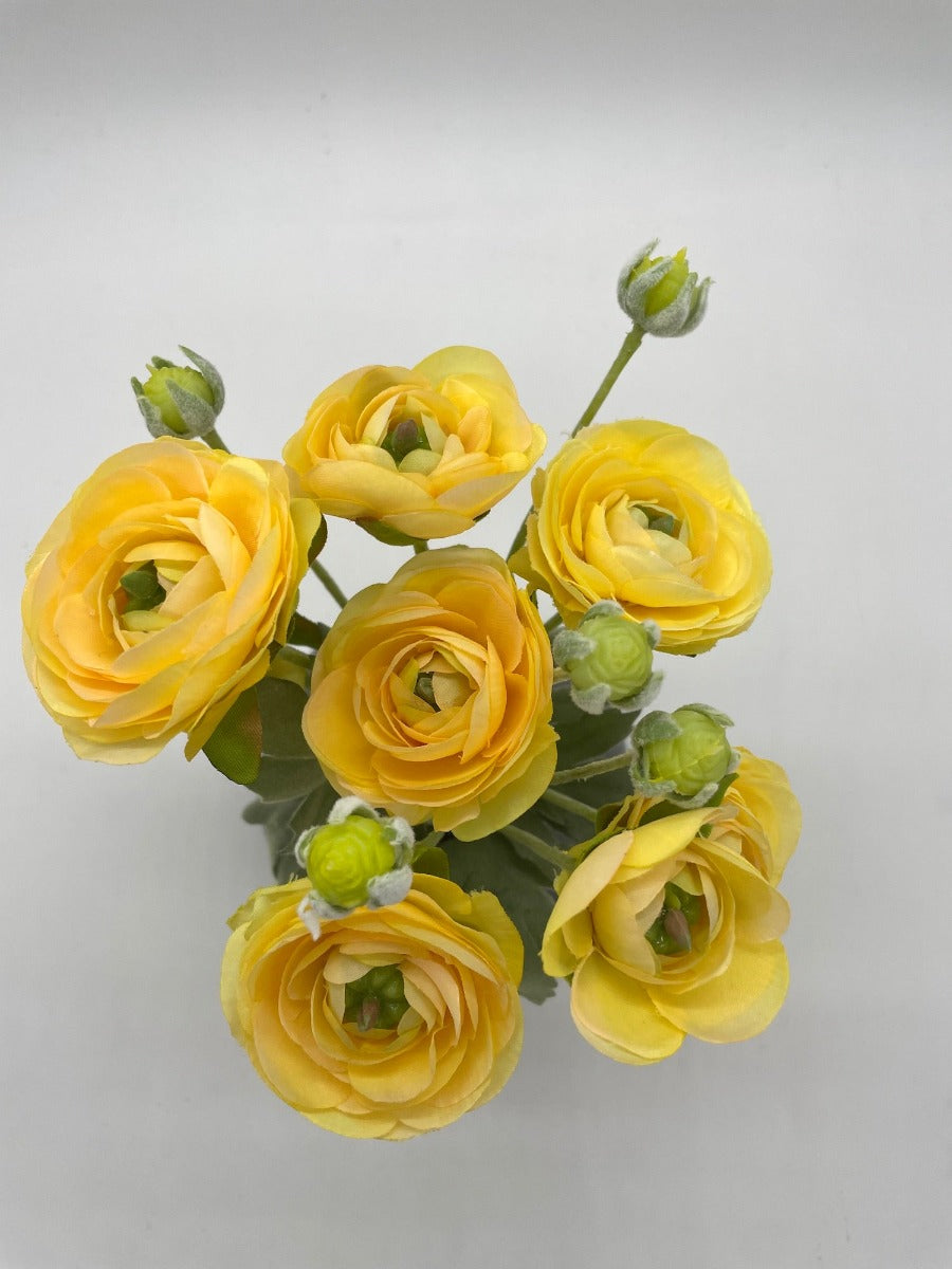view from top of yellow ranunculus bouquet in gray ceramic vase 