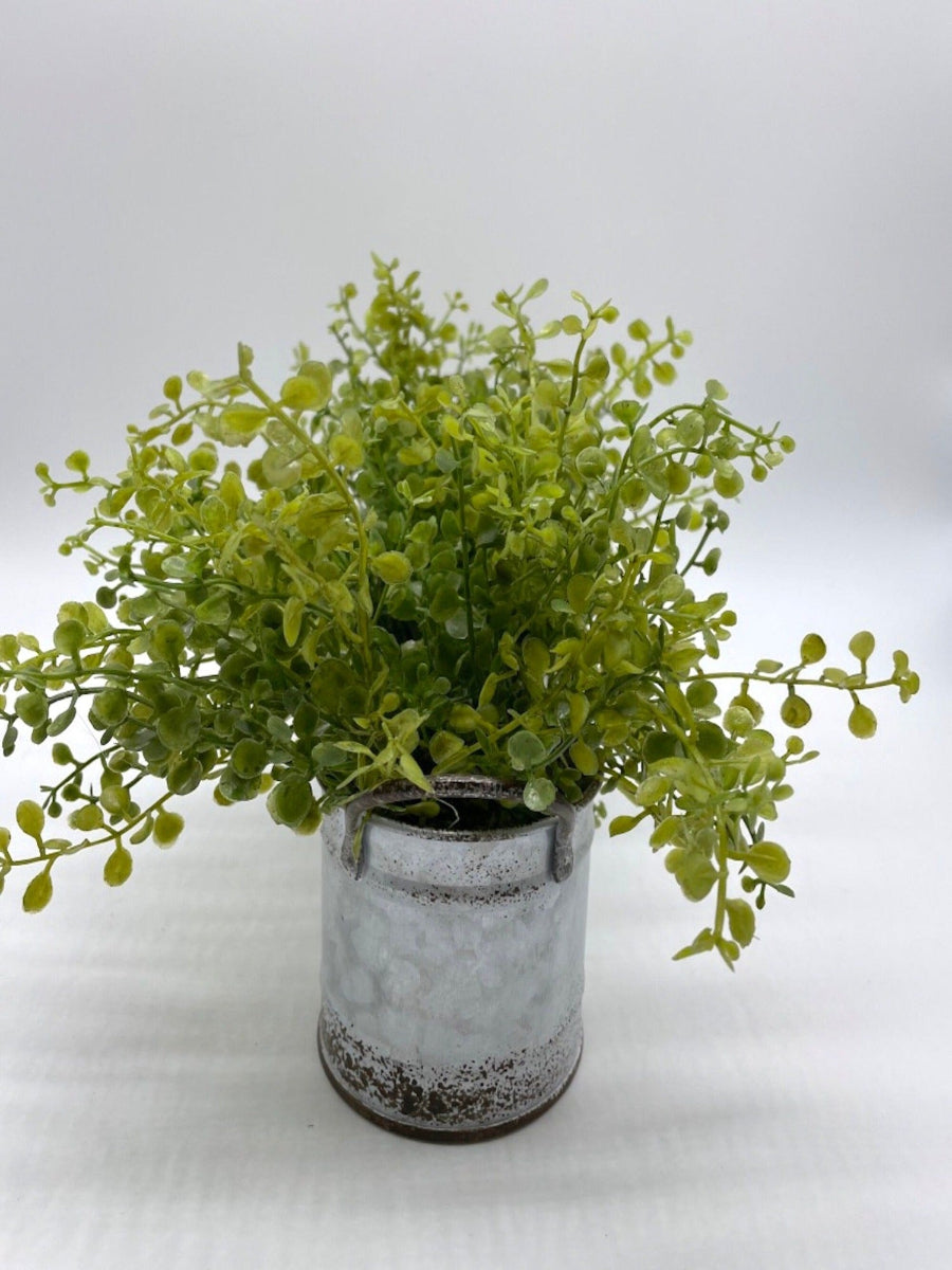 side view of vivid green faux greenery in triple can metal galvanized planter with handles decorated with jute, in modern farmhouse style