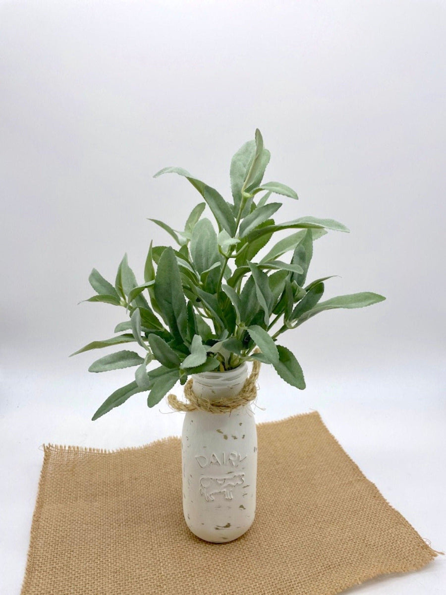 realistic looking faux sage plant arrangement in Dairy bottle vase painted in white and distressed and decorated with rope