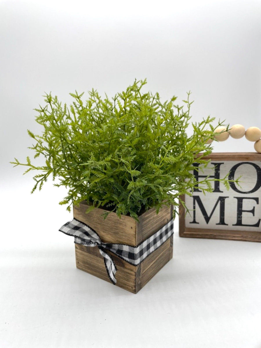 realistic faux plant fern in square wooden planter decorated with black white ribbon