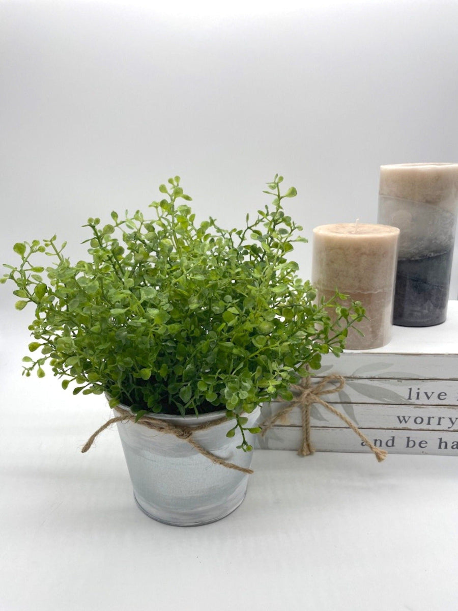 vivid green realistic greenery in metal galvanized pot touched with white paint and decorated with jute