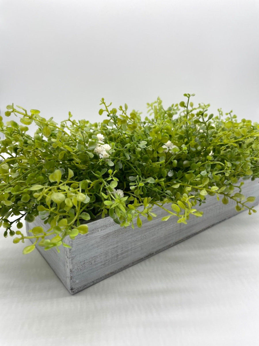 realistic looking vivid green faux Greenery Arrangement with delicate white flowers  in long Whitewashed Wooden Planter