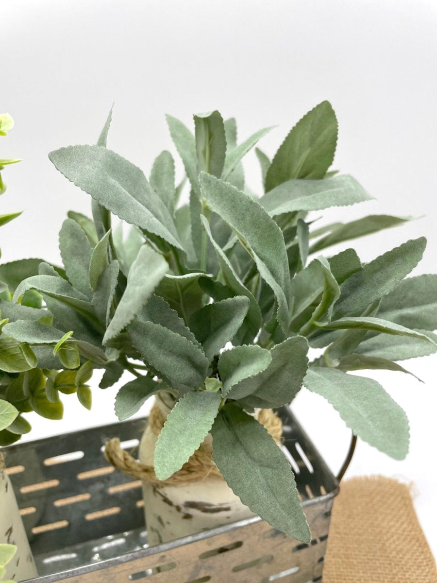 close up for sage  - faux Plants in Metal Basket tray with two glass bottle vases painted in ivory and distressed and decorated with jute