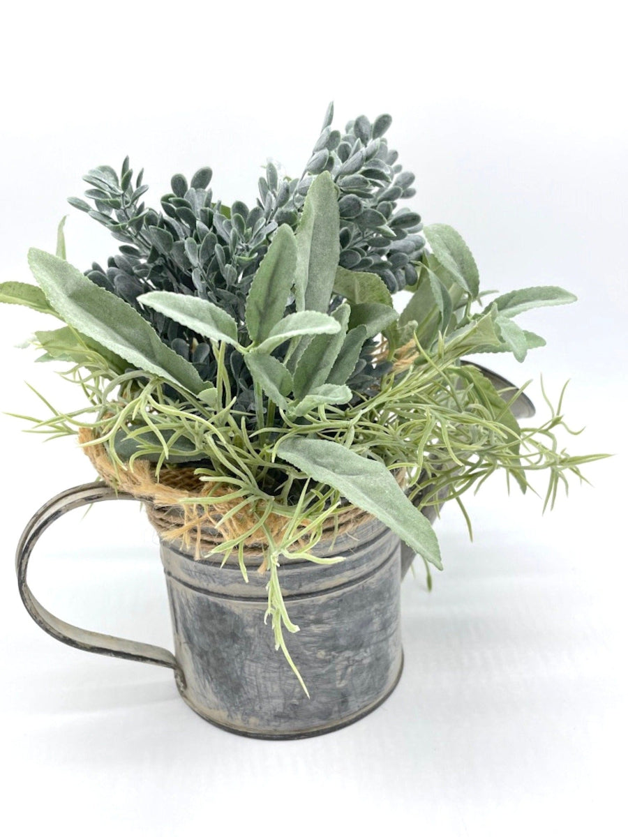 side view of realistic Greenery Arrangement with 3 types of plants in dusty green in Metal Watering Can decorated with burlap and jute