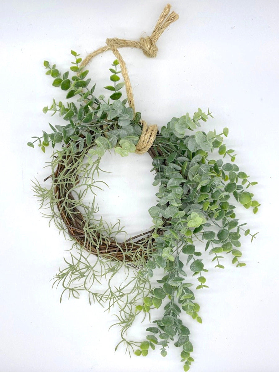 lush handmade eucalyptus wreath with greenery on grapevine base finished with rope to hang wreath on wall or door