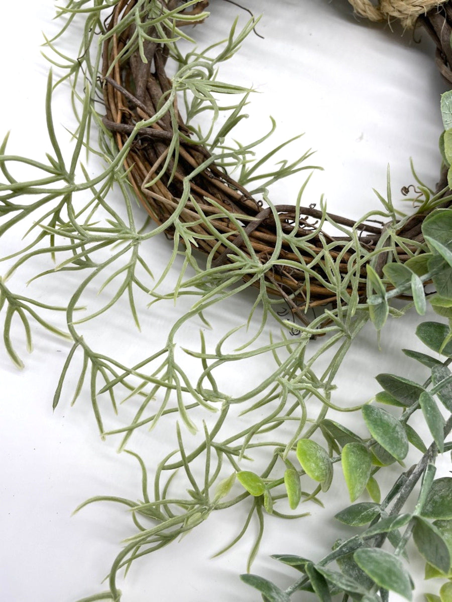 lush handmade eucalyptus wreath with greenery on grapevine base finished with rope to hang wreath on wall or door