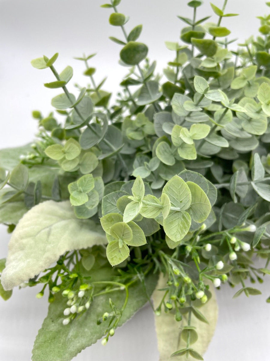 close up for realistic looking faux eucalyptus with lambs ear leaves and delicate white flowers in whitewashed wooden planter box