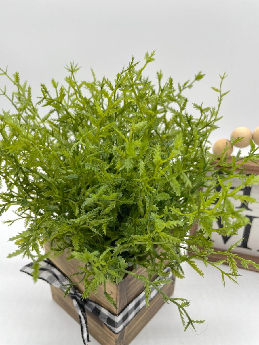 view from top realistic faux plant fern in square wooden planter decorated with black white ribbon
