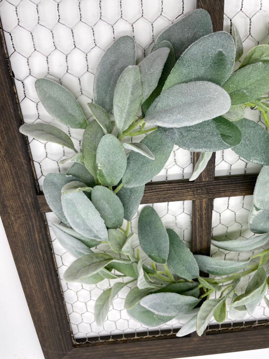 wooden window frame with chicken wire and decorated with lambs ear wreath