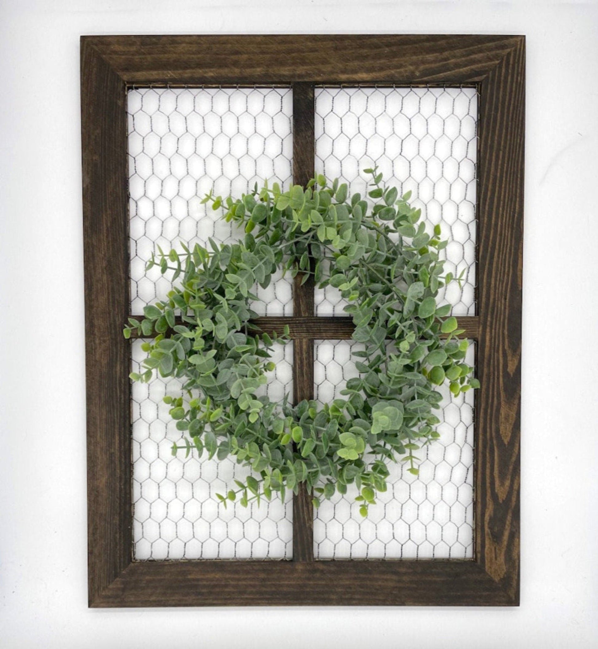 window frame with chicken wire decorated with realistic green eucalyptus wreath